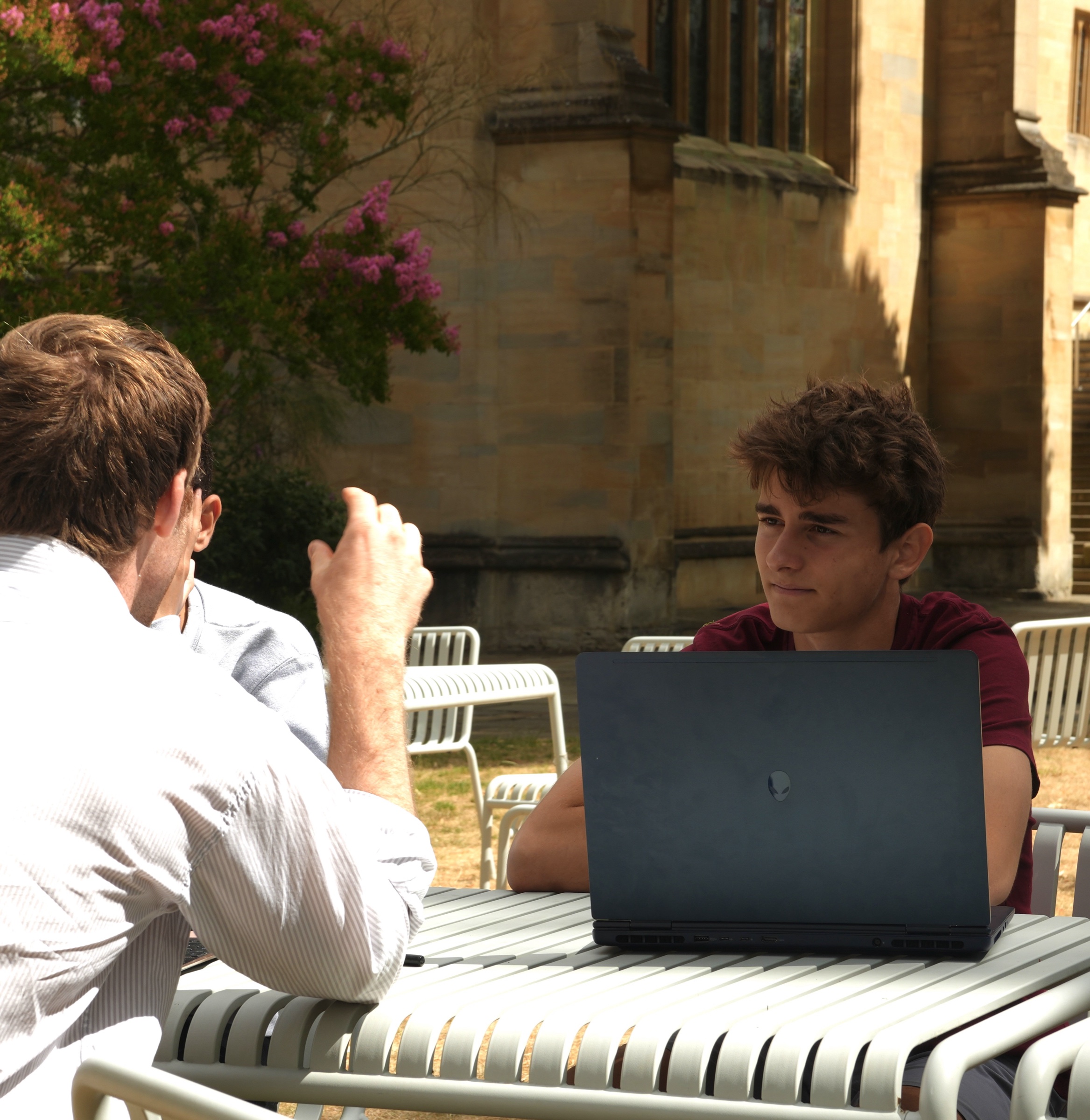 An academic and student in an Oxford-style tutorial outdoors